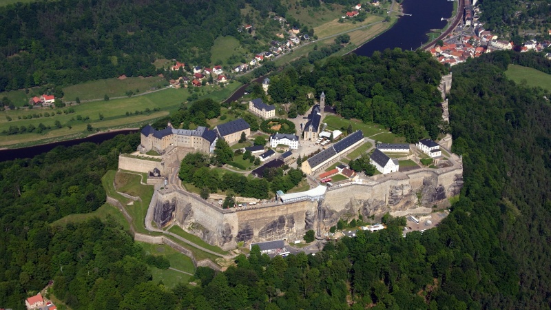 Flygbild over slottet Konigstein med grona omgivande kullar